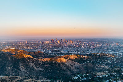 Aerial view of cityscape against sky during sunset