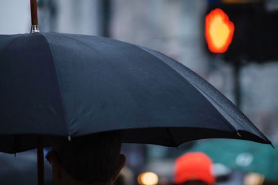Rear view of man carrying umbrella
