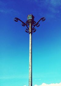 Low angle view of communications tower against blue sky