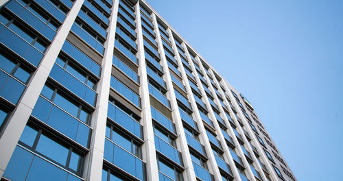 Low angle view of modern building against clear blue sky