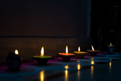 Illuminated tea light candles in building