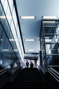 Low angle view of people walking on staircase in building