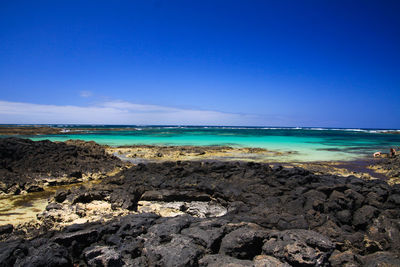 Scenic view of beach against blue sky