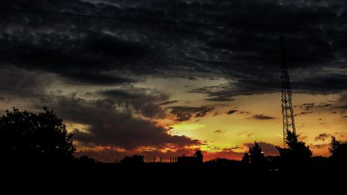 Silhouette of trees against dramatic sky