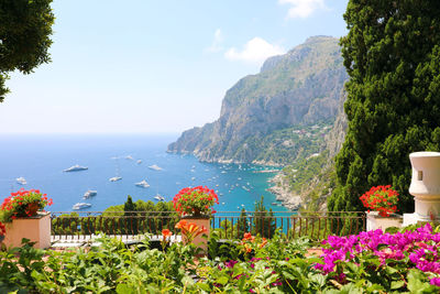 Scenic view of sea by mountains against sky