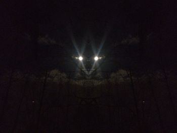 Low angle view of illuminated street light against sky