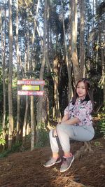 Girl sitting on tree trunk