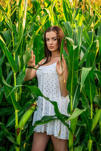 Young woman standing against plants