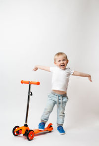 Portrait of cute boy with toy against white background