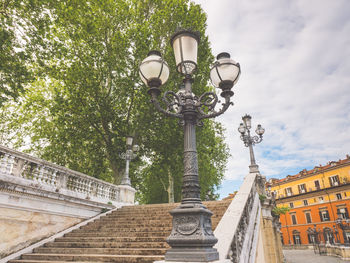 Low angle view of street light by building against sky