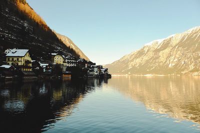 Scenic view of lake by buildings against sky