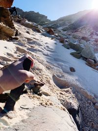 Midsection of person on rocks at shore