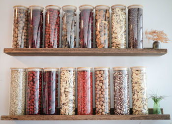 Close-up of multi colored jars in shelf at home