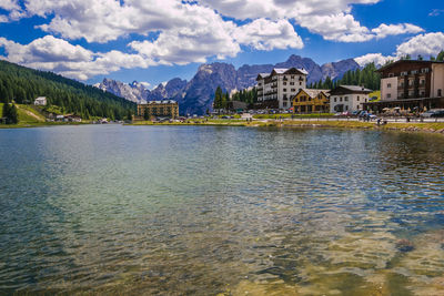 Scenic view of lake by buildings against sky