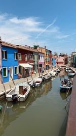 Boats moored at harbor by buildings in city