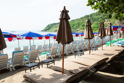 Chairs on beach against sky