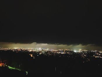 High angle view of illuminated buildings against sky at night