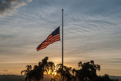 Low angle view of flag against sky during sunset