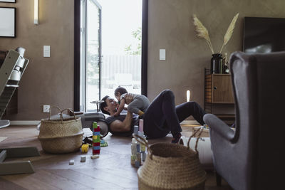 Father spending leisure time while playing with son in living room at home