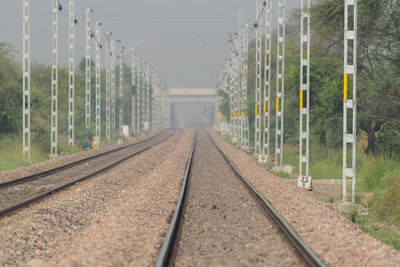 Railroad tracks by trees against sky