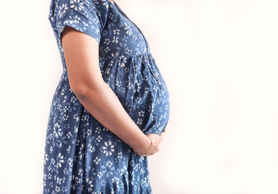 Midsection of woman standing against clear sky