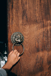 Close-up of human hand holding door knocker