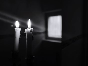 Close-up of lit candles in darkroom