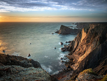 The last rays of light illuminating the seacliffs at arrifana on the atlantic coast of portugal