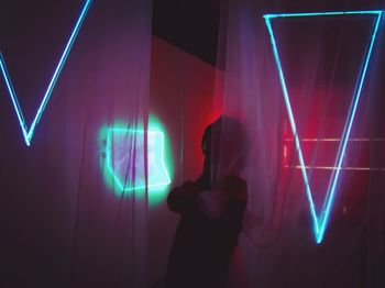 Midsection of woman photographing illuminated at night