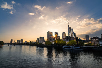 View of buildings at waterfront during sunset