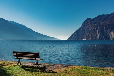 Scenic view of lake and mountains against clear blue sky