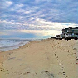 Scenic view of beach against cloudy sky