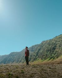 Full length of man standing on field against mountain