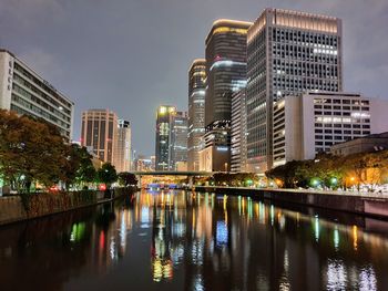 Reflection of illuminated buildings in river at night