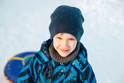 Portrait of smiling boy standing outdoors during winter