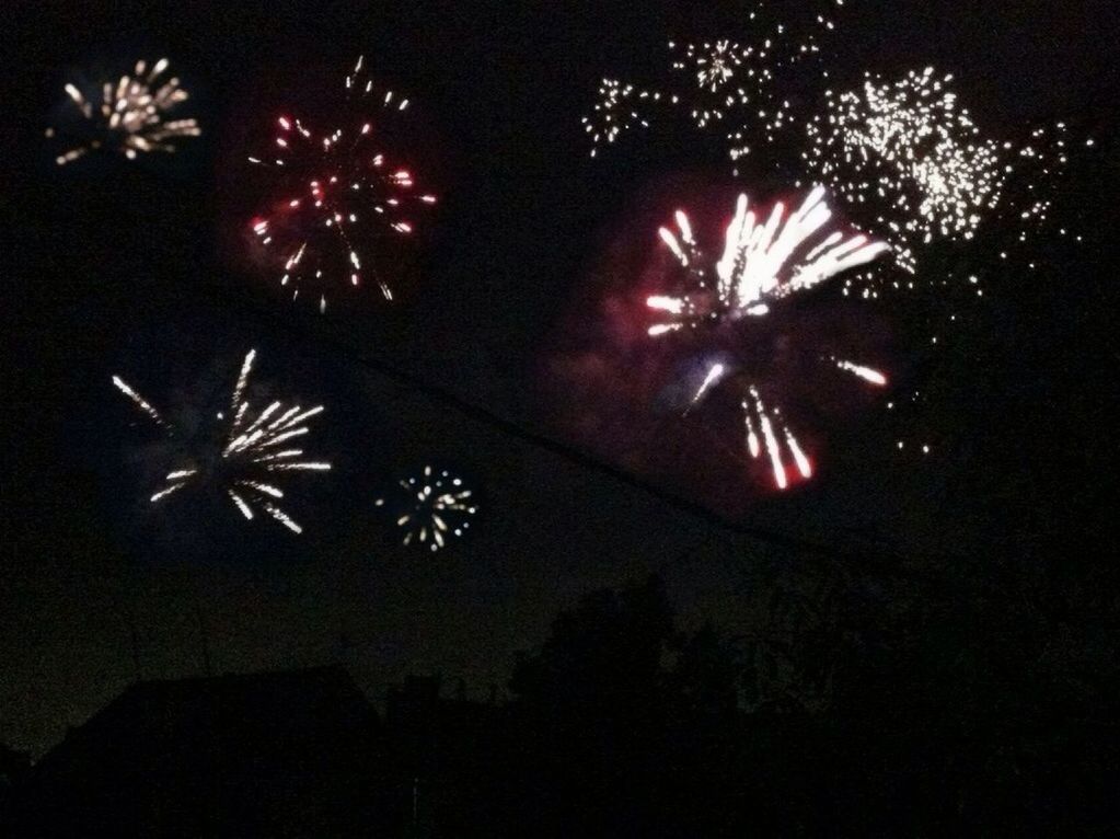 night, illuminated, firework display, celebration, exploding, glowing, firework - man made object, sparks, long exposure, arts culture and entertainment, event, low angle view, firework, motion, fire - natural phenomenon, entertainment, dark, celebration event, sky, blurred motion