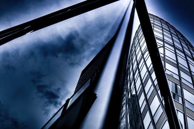 Low angle view of modern building against cloudy sky