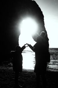 Silhouette man with arms outstretched at night