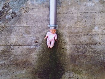 Portrait of girl standing against wall