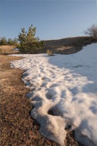 Scenic view of land against clear sky during winter