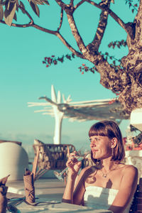 Portrait of smiling young woman sitting on table