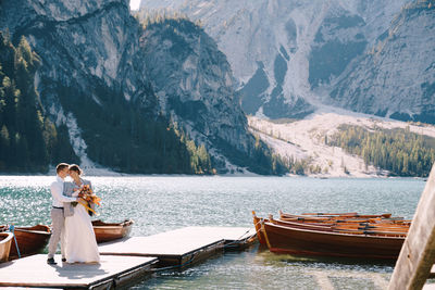 Woman sitting on boat in lake against mountains