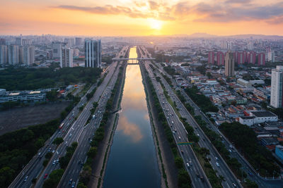 High angle view of illuminated cityscape against sky during sunset