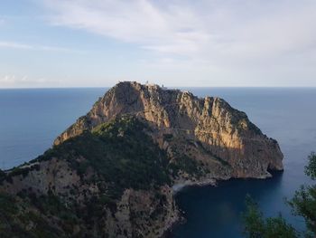 Rock formations by sea against sky