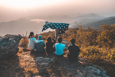 Rear view of people on mountain against sky