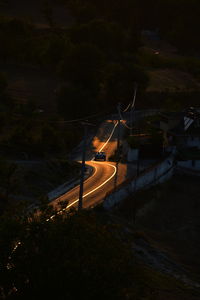 High angle view of illuminated road amidst buildings at night