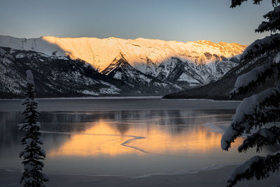 Scenic view of lake and mountains against sky during winter