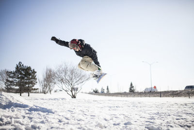 Young snowboarder in mid air doing jump
