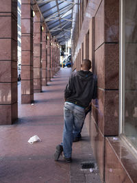 Rear view of man walking on corridor of building