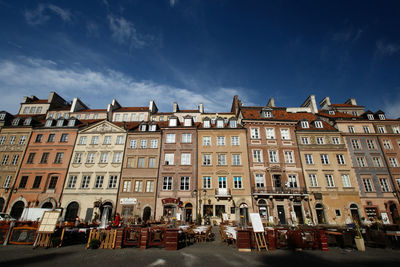 Low angle view of buildings against blue sky on sunny day